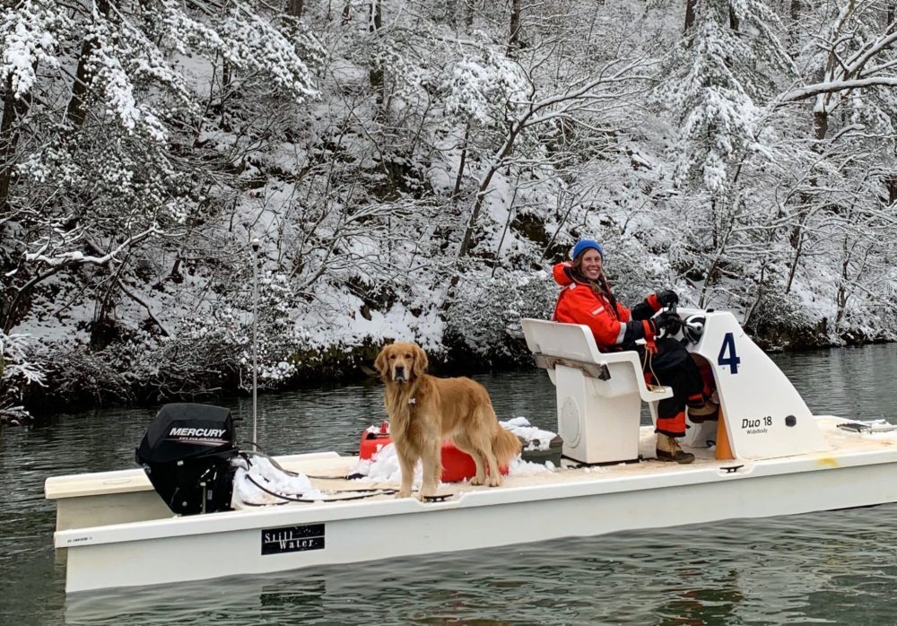 Kelsie Chaudoin sitting on a boat with her dog in the snow