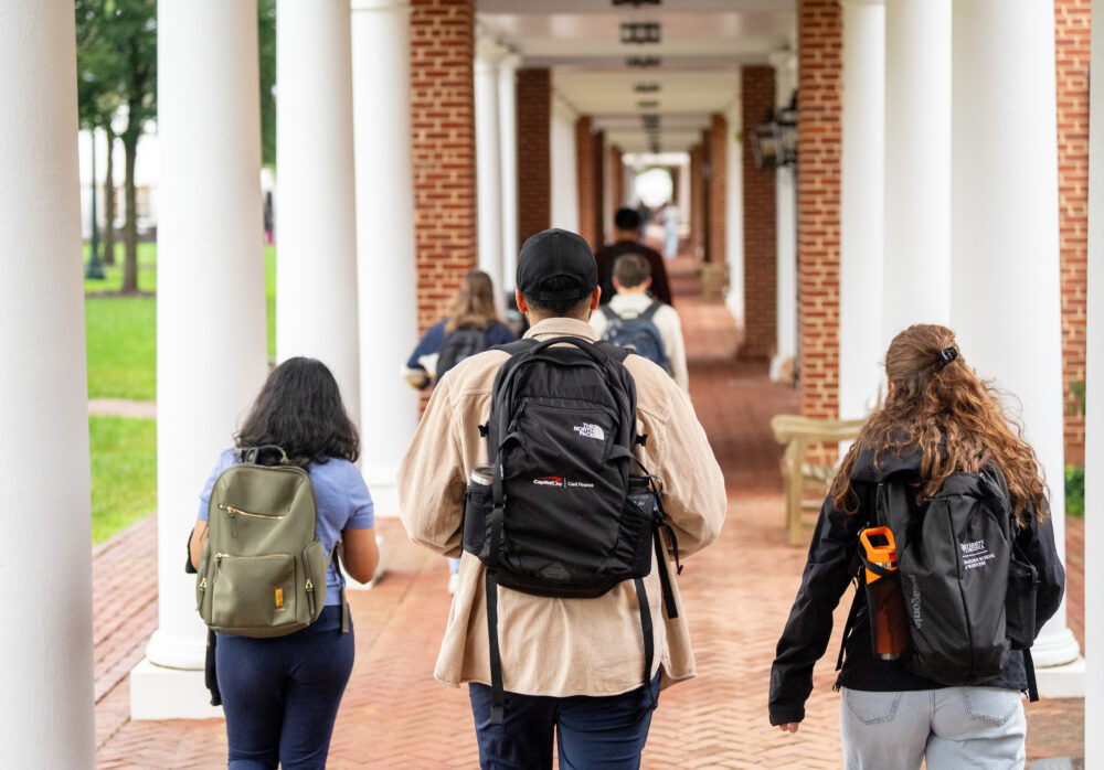 Darden students walking away down brick path with white columns